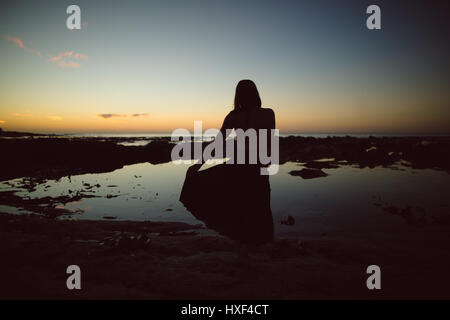 Silhouette de femme dansant au crépuscule Banque D'Images