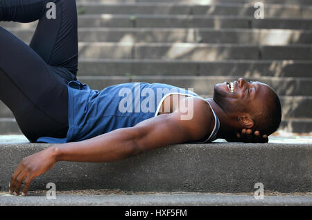 Smiling young man lying down on retour à l'extérieur Banque D'Images