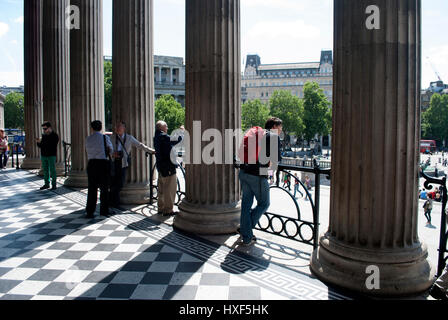 Les touristes à l'extérieur de l'entrée de la la Galerie Nationale avec St Martins dans le domaine de l'église distance derrière les piliers Banque D'Images