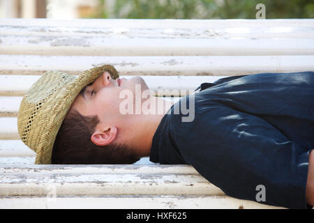 Autre portrait d'un homme dormant sur banc de parc à l'extérieur Banque D'Images