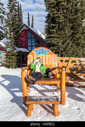 Skieur femme dispose d'une secousse avant de frapper les pentes de ski à Big White en Colombie-Britannique, Canada. Banque D'Images