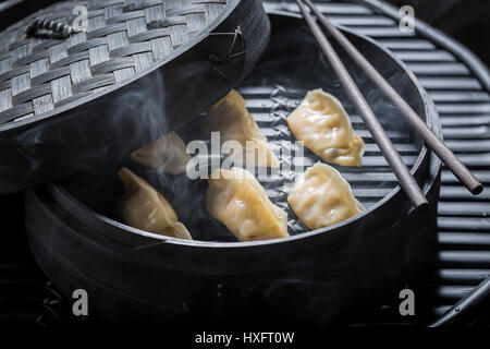 Chaud et savoureux gyoza boulettes en bamboo steamer Banque D'Images