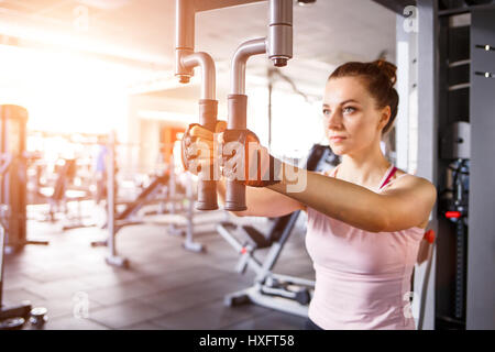 Jeune femme papillon faisant de l'exercice dans le centre de remise en forme Banque D'Images