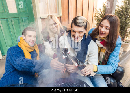 High angle view of woman sitting on porch avec de la bière sur le barbecue Banque D'Images