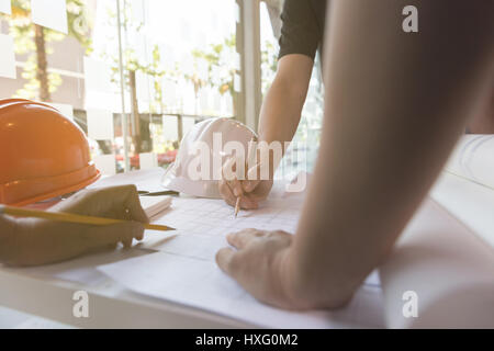 Réunion ingénieur pour des projets architecturaux, en collaboration avec ses partenaires des outils d'ingénierie et sur le lieu de travail. Sur le plan de travail de l'architecte. Construction conc Banque D'Images