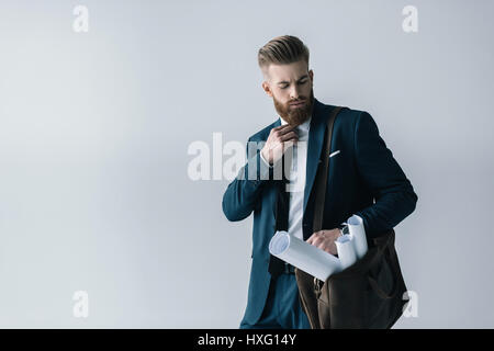 Jeune homme barbu avec les bleus en bandoulière sac adjusting tie Banque D'Images