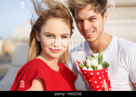 Jeune femme blonde en robe rouge avec petit ami anniversaire, Banque D'Images