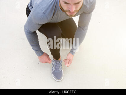 Portrait d'un homme attacher les lacets de chaussures de sport Banque D'Images