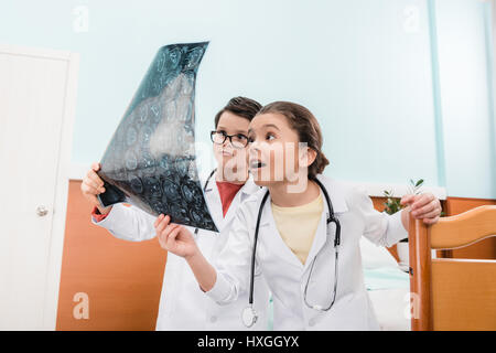 Choqué garçon et fille doctors looking at x-ray image à l'hôpital Banque D'Images