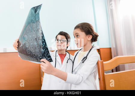 Choqué garçon et fille doctors looking at x-ray image à l'hôpital Banque D'Images