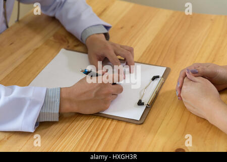 Médecin spécialiste en médecine des hommes de main tenir pen écrit quelque chose sur le presse-papiers. Ward round, visite du patient vérifier, medical concept. Patient médecin examiner Banque D'Images
