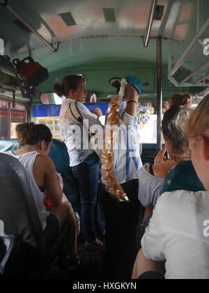 La population locale à la gare routière de Grenade se vendent des aliments dans les transports publics pour les touristes. Bus de poulet, voyageant avec les habitants Banque D'Images