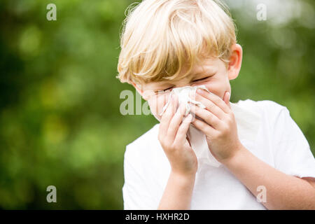 Enfant avec un tissu froid d'éternuements et de tenir sur son nez Banque D'Images