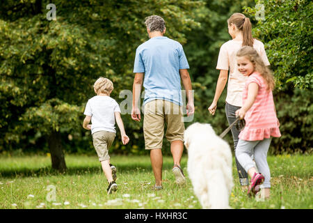 Famille et girl walking dog en été dans la nature Banque D'Images