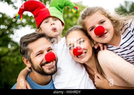 Famille portant les costumes et nez rouge s'amuser au carnaval Banque D'Images