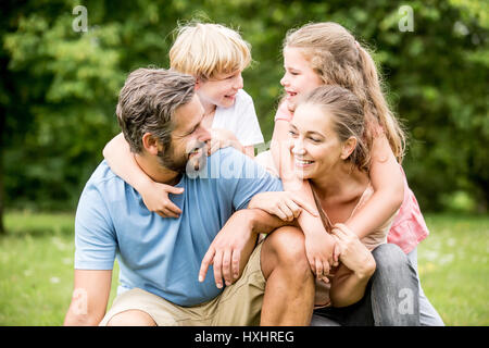 Les enfants et les parents comme une famille heureuse ensemble dans un gros câlin Banque D'Images