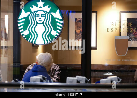 New Westminster, BC, Canada - Mars 03, 2017 : un côté de gens de boire du café et à discuter à l'intérieur magasin Starbucks Banque D'Images