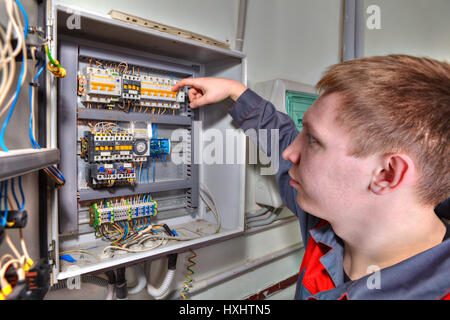 Saint-pétersbourg, Russie - 5 mars 2013 : Ingénieur électricien effectue la réparation d'un coupe-circuit en standard industriel. Banque D'Images