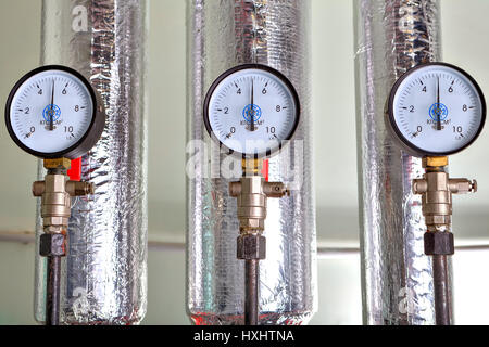 Les manomètres à la chaufferie près les tuyaux de chauffage avec revêtement d'isolation. Banque D'Images