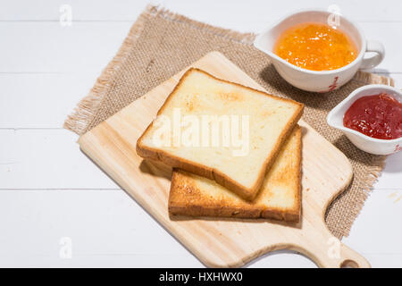 Toast avec confiture de fraise et d'orange sur une assiette sur la table. Banque D'Images