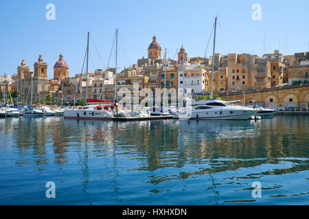 BIRGU, MALTE - Juillet 23, 2015 : l'avis de bâtiments historiques à travers l'arsenal creek avec les yachts et bateaux amarrés dans le port, Birgu, Malt Banque D'Images