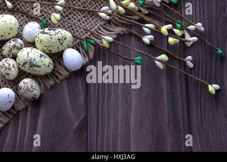Les oeufs de Pâques sur un chiffon de toile avec des branches Banque D'Images