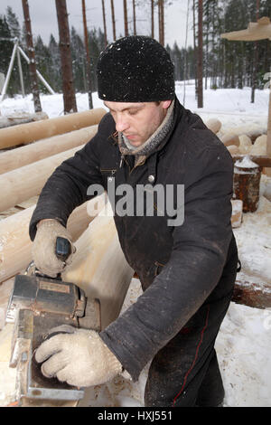 Leningrad Region, Russie - Février 2, 2010 : le sablage d'un journal à l'aide d'une raboteuse électrique. Banque D'Images