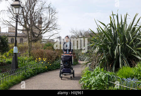 Brighton, UK. Mar 28, 2017. Une jeune femme avec son bébé de promenades à travers les jardins du Pavillon de Brighton comme le printemps chaud temps persiste tout au long de la Grande-Bretagne aujourd'hui, certains secteurs s'attendent à atteindre 19 degrés Crédit : Simon Dack/Alamy Live News Banque D'Images