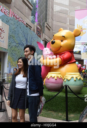 Hong Kong, Chine. Mar 29, 2017. Des touristes posent pour des photos au cours d'une exposition de Winnie l'Ourson à Hong Kong, en Chine, le 29 mars 2017. Credit : Qin Qing/Xinhua/Alamy Live News Banque D'Images