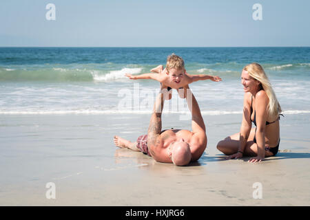 Jeune famille s'amusant sur la plage Banque D'Images
