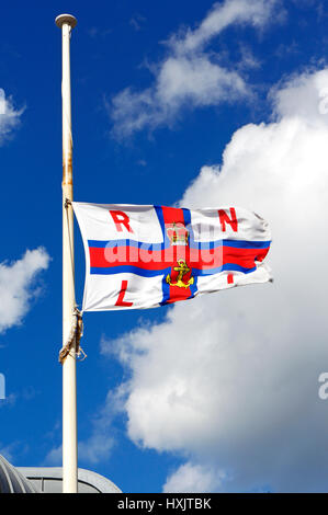 Un drapeau RNLI volant en Berne devant la station du canot de sauvetage, à l'extrémité de la jetée de North Norfolk, à Cromer, Norfolk, Angleterre, Royaume-Uni. Banque D'Images