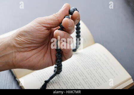 Male hand holding rosary coran et gros plan sur l'arrière-plan. Banque D'Images