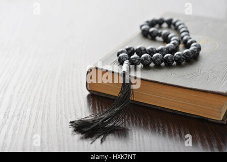 Saint Coran avec perles sur fond de bois libre. Petits DOF. Banque D'Images