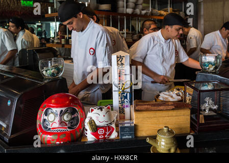 Les cuisiniers s'affairent derrière un bar à sushis au restaurant Maido. Lima, Pérou. Banque D'Images