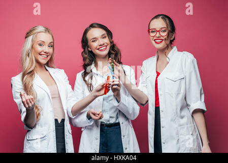 Portrait of smiling doctors holding trois tubes à essai sur Rose Banque D'Images