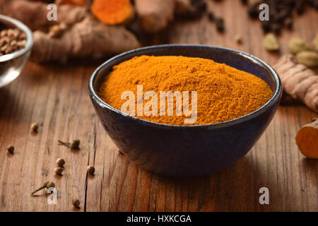 Rez-de poudre de curcuma dans un bol sur fond de bois. Épices en bonne santé. Banque D'Images