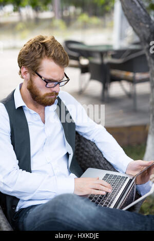 Red-haired opérateur travaillant dans patio Banque D'Images