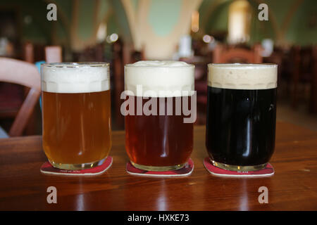 Trois verres de bières différentes on wooden table in restaurant Banque D'Images