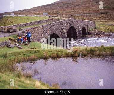 Les cyclistes par pont de pierre, l'île de Skye, Hébrides intérieures, Highland, Ecosse, Royaume-Uni Banque D'Images