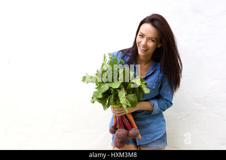 Portrait of a smiling woman holding bunch of vegetables Banque D'Images