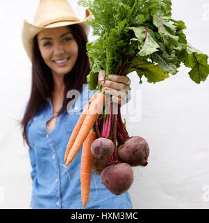 Close up portrait of a smiling woman holding carottes et betteraves Banque D'Images