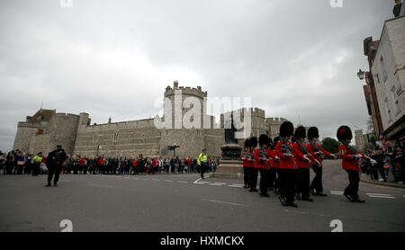 Un agent de police armé se tient avec public au cours de la relève de la garde au château de Windsor dans le Berkshire. Banque D'Images