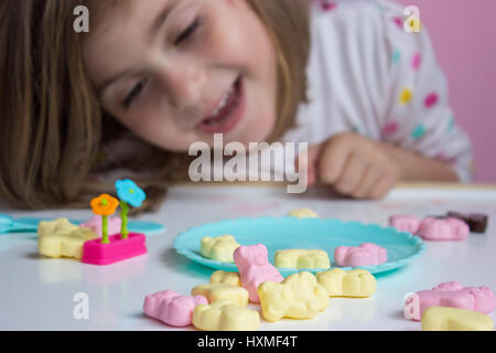 Petite fille jouant avec des bonbons ; profondeur de champ Banque D'Images