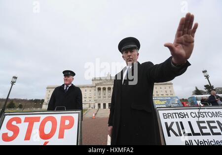 Anti-Brexit participants habillés comme des agents des douanes, de protestation à l'extérieur de Stormont, à Belfast, en tant que premier ministre Theresa peut déclencher l'article 50, le démarrage du processus qui fera en sorte que la Grande-Bretagne quitter l'UE. Photo date : mercredi 29 mars, 2017. Voir la politique histoire Brexit PA L'Ulster. Crédit photo doit se lire : Brian Lawless/PA Wire Banque D'Images