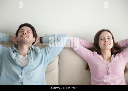 Heureux jeune homme et femme assise reposant, avec les yeux fermés Banque D'Images