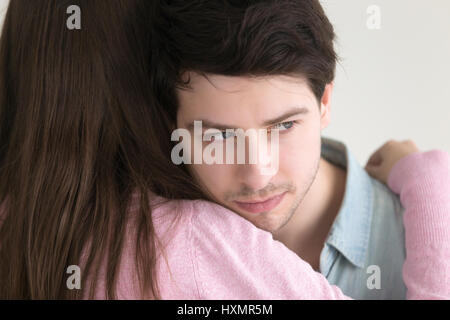 Young man embracing dame à la voiture, perdu dans si Banque D'Images