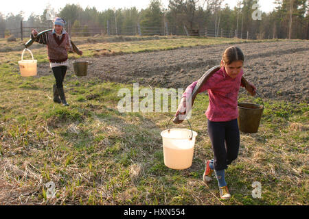 Lipovec village ; région de Tver, Russie - 2 mai ; 2006 : Farmer girl russe portant de l'eau des seaux Banque D'Images