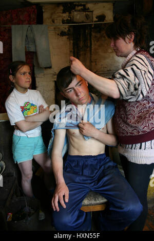 Lipovec village, région de Tver, Russie - Mai 7, 2006 : les agriculteurs russes de la famille dans sa maison mère, coupes de cheveux fils dans la cuisine de maison rurale, peuple de paysans Banque D'Images