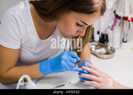 Peinture des ongles avec une brosse à ongles sur femme mains Banque D'Images