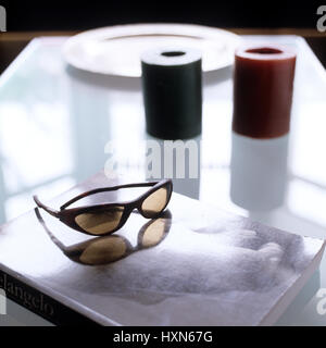 Lunettes de soleil et livre sur une table basse. Banque D'Images